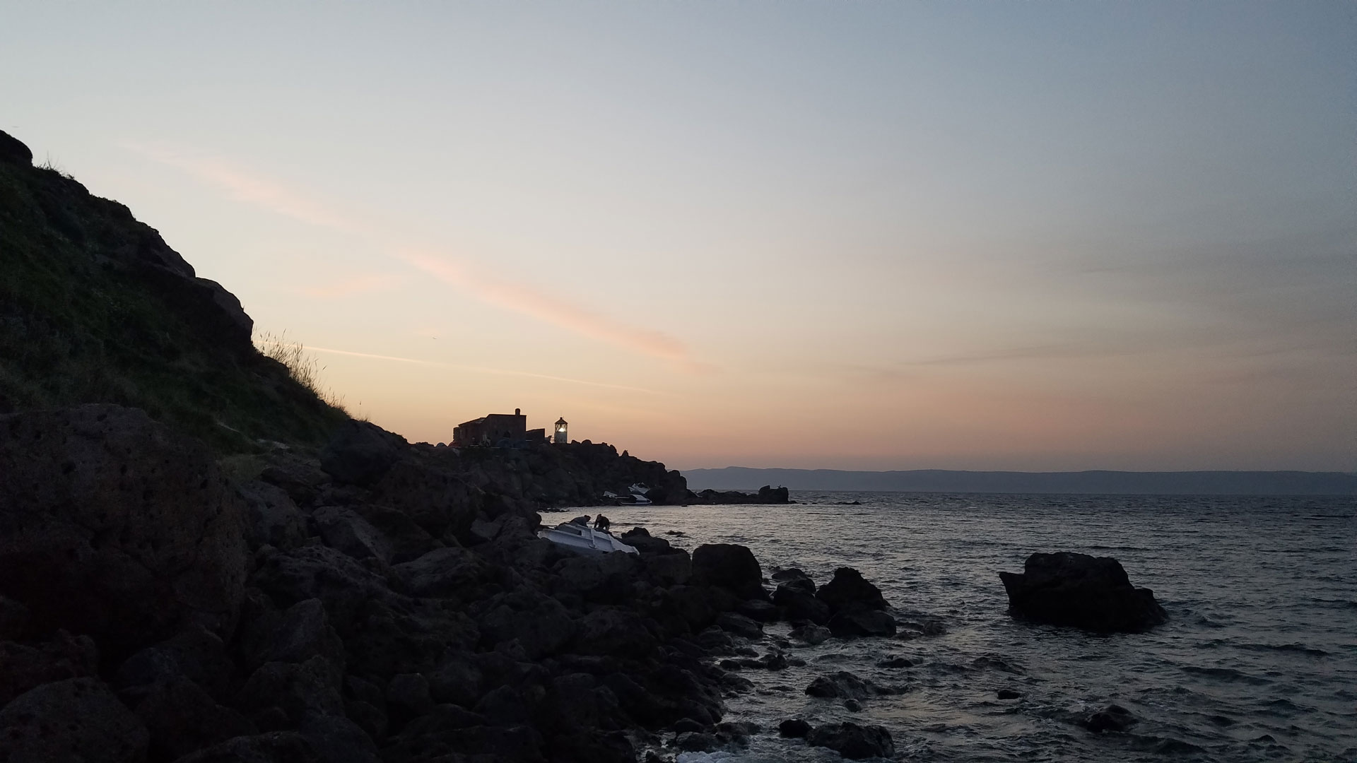 A photo of Koraas lighthouse silhouetted against the setting sun.
